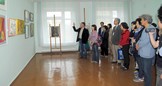  знакомит гостей с выставкой картин